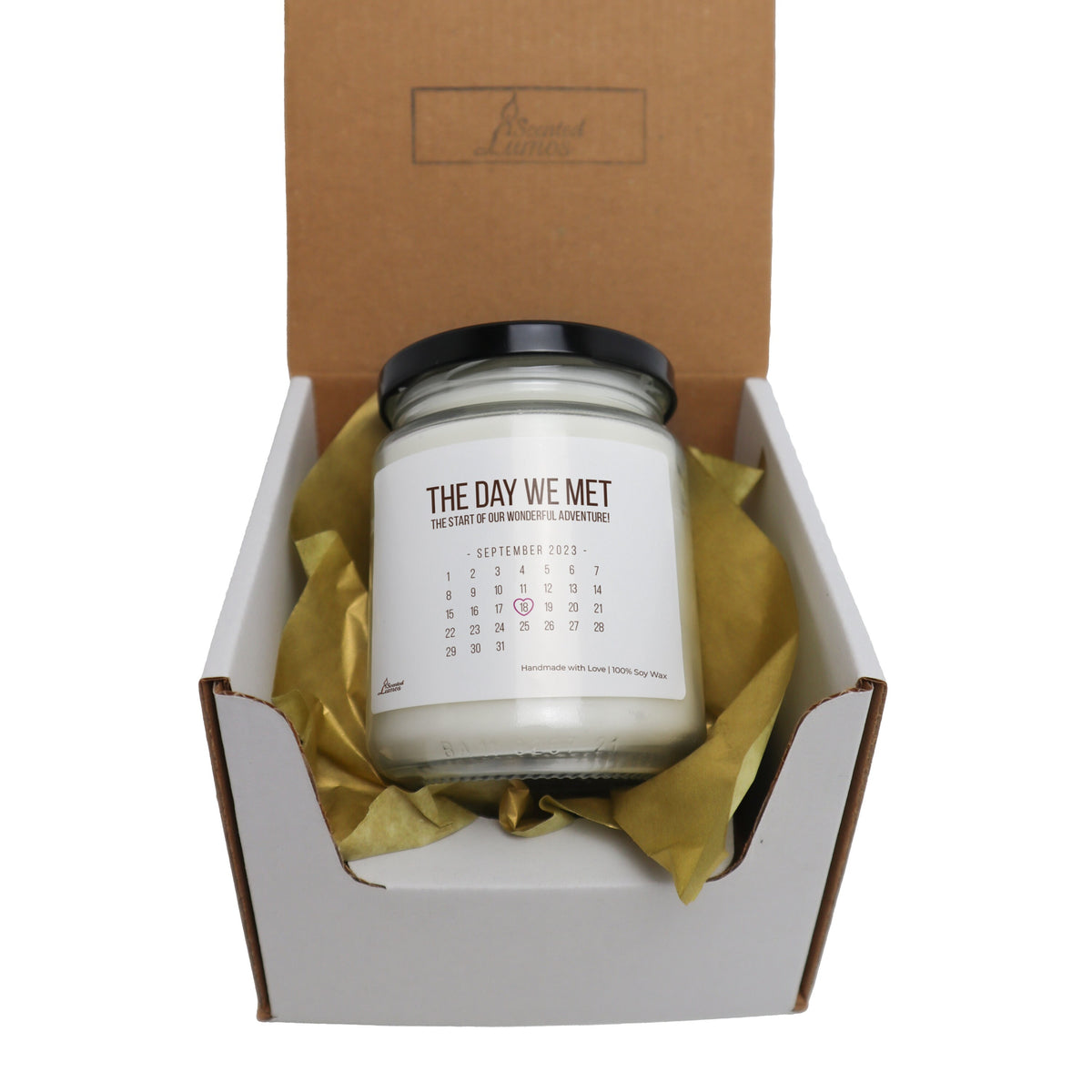 a candle in a gift box with a calendar on it