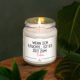 a lit candle sitting on top of a wooden table