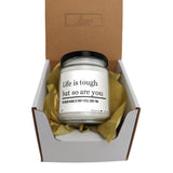 a candle in a box that says life is tough but so are you