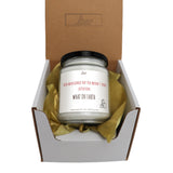 a candle in a box with a brown ribbon around it