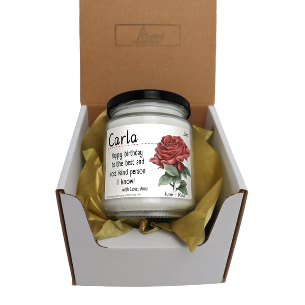 a candle in a box with a rose on it
