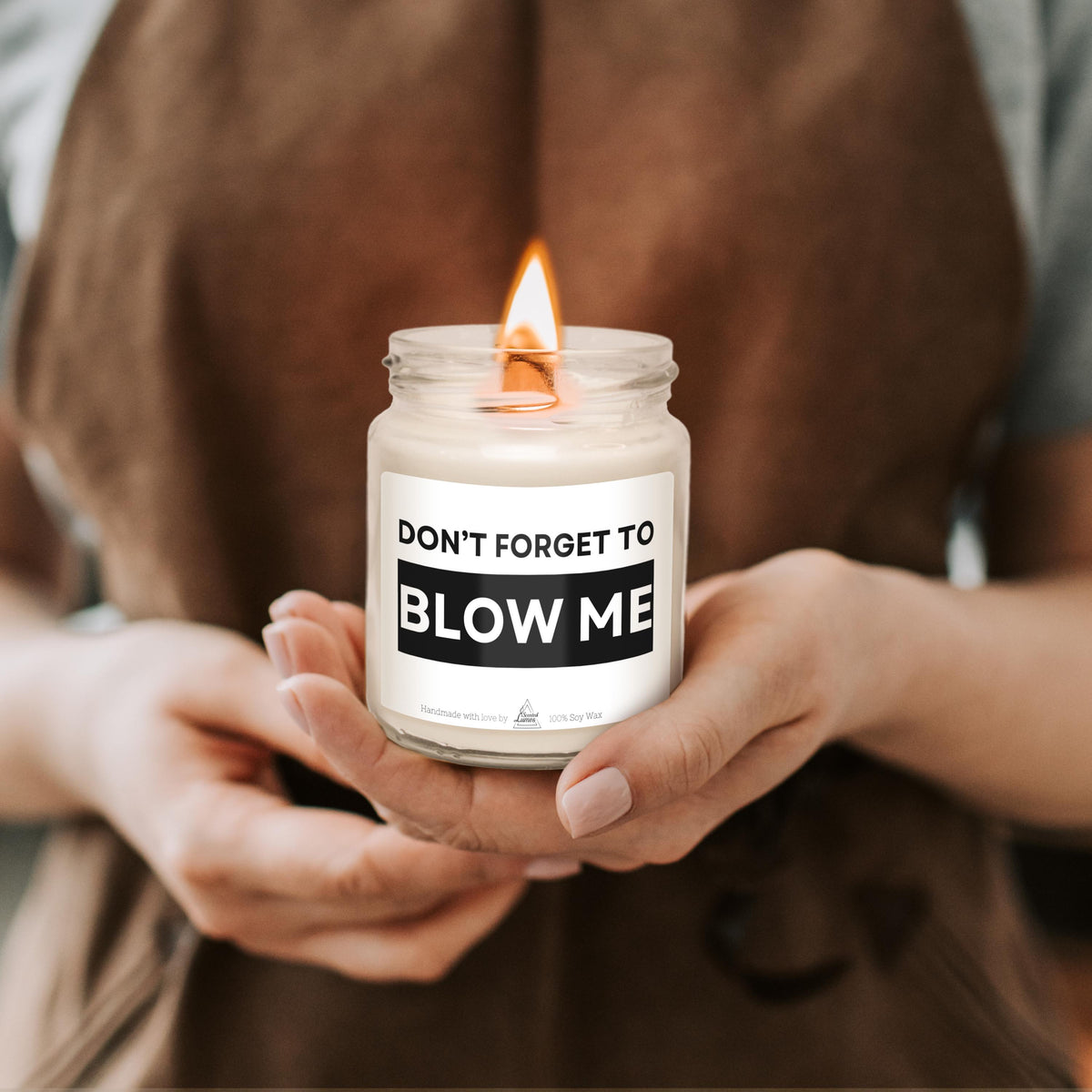 a woman holding a candle that says don't forget to blow me