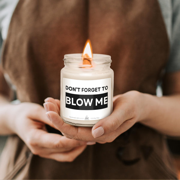 a woman holding a candle that says don't forget to blow me